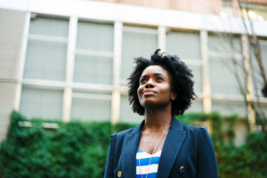 Black woman looking up in a thoughtful manner. As a board member, she wants to serve her community and its residents.