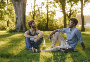 Two friends sitting in a park, having a discussion about diversity and inclusion.