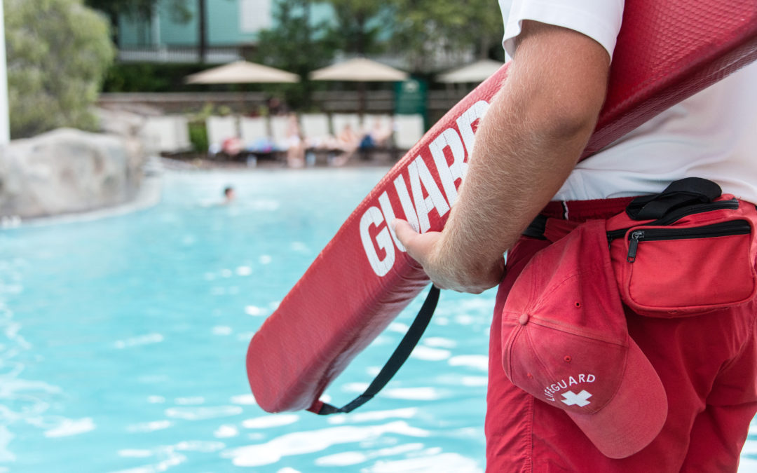 Lifeguard watching a swimming pool. Lifeguard shortages have been an ongoing issue in the U.S. for year.