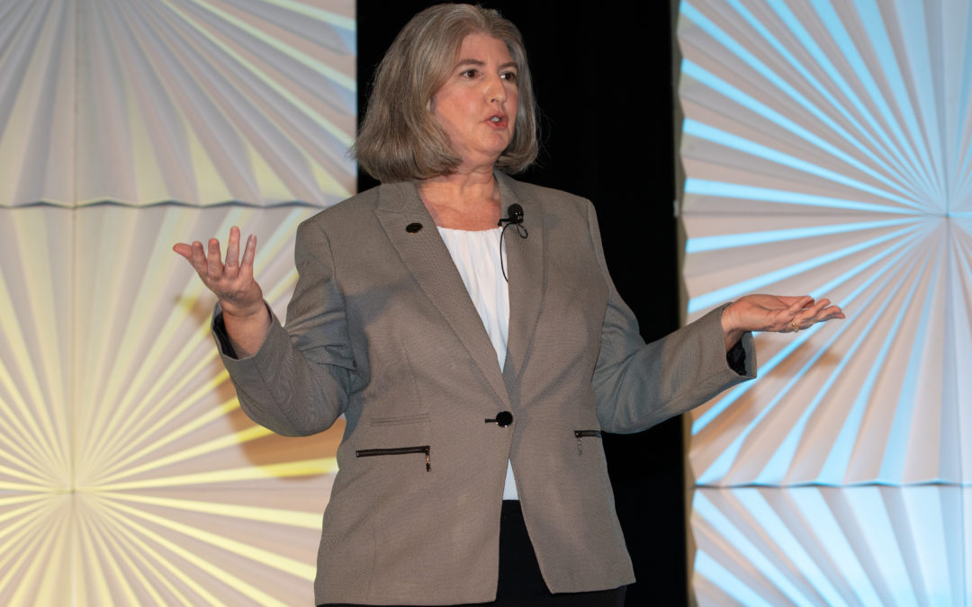 Laurie Poole, an attorney at Adams Stirling law firm in California and president of the 2022 College of Community Association Lawyers' Board of Governors, presents at the 2022 Community Association Law Seminar in La Quinta, Calif. She's standing up and wearing a gray blazer over a white blouse.